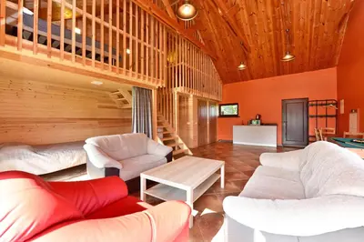 a living room with white furniture and wooden ceilings at Spacious Loft in the Nature in Molėtai