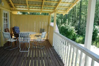 a wooden deck with a table and chairs on it at Sodyba - Antalieptės marios in Zarasai