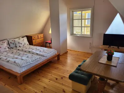 a bedroom with a bed and a table and a desk at Sodyba - Antalieptės marios in Zarasai