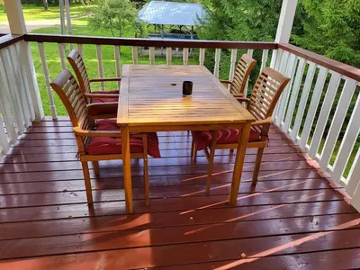 a wooden table and chairs on a deck at Sodyba - Antalieptės marios in Zarasai