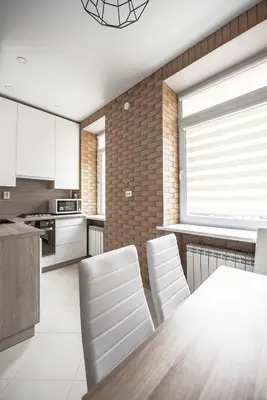 a kitchen with white chairs and a wooden table at Valeri Aprtment in Kaunas