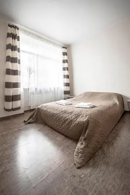a bed in a bedroom with a large window at Valeri Aprtment in Kaunas