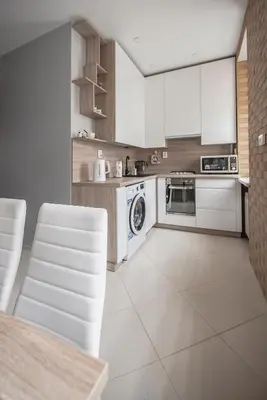 a kitchen with white appliances and a table and chairs at Valeri Aprtment in Kaunas