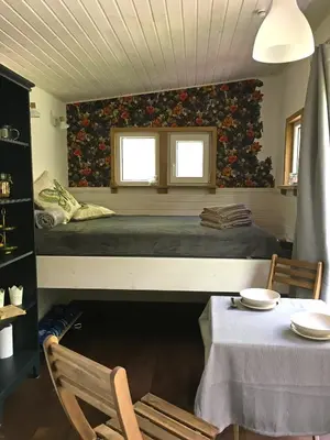 a bedroom with a bed and a table and a window at Inkilas in Sidabrinės