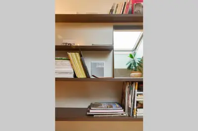 a book shelf with books and a plant on it at Penthouse Apartment with Great Panoramic City View in Vilnius