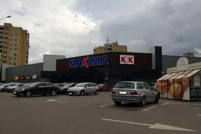 a parking lot with cars parked in front of a mall at Penthouse Apartment with Great Panoramic City View in Vilnius