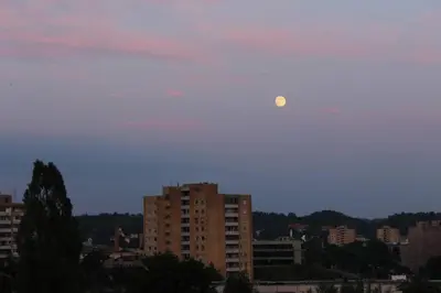 a moon in the sky over a city at Penthouse Apartment with Great Panoramic City View in Vilnius