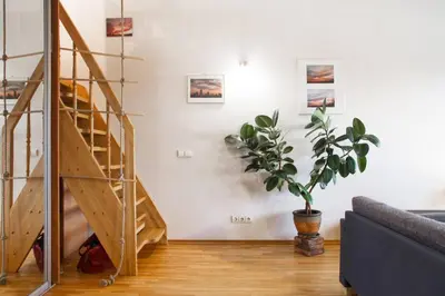 a staircase in a living room with a potted plant at Penthouse Apartment with Great Panoramic City View in Vilnius