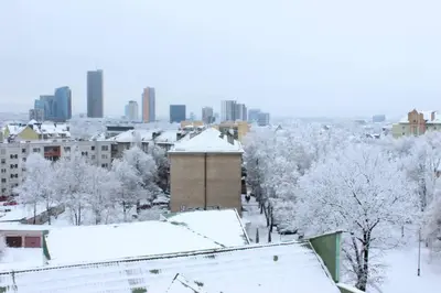 a city covered in snow with buildings and trees at Penthouse Apartment with Great Panoramic City View in Vilnius