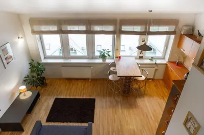 a living room with a table and two windows at Penthouse Apartment with Great Panoramic City View in Vilnius