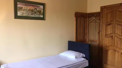 a bedroom with a bed and a wooden door at Šeduvos malūnas in Šiauliai