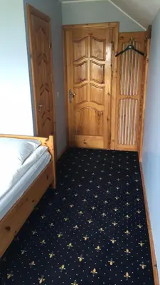 a bedroom with a bed and a wooden door at Šeduvos malūnas in Šiauliai