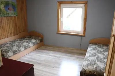 a room with two beds and a window at Nakvynė apgyvendinimo paslaugos DAIVOS NAKVYNĖS NAMAI in Biržai