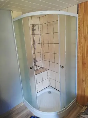 a shower with a glass enclosure in a room at Nakvynė apgyvendinimo paslaugos DAIVOS NAKVYNĖS NAMAI in Biržai