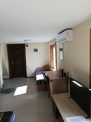 a room with a room with a desk and a table at Nakvynė apgyvendinimo paslaugos DAIVOS NAKVYNĖS NAMAI in Biržai
