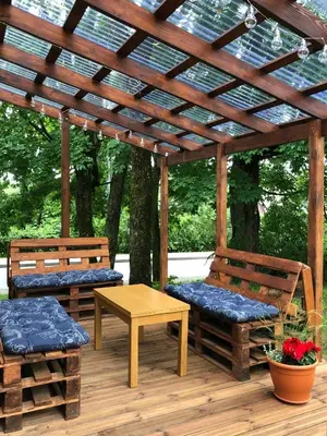 a wooden pergola with two benches and a table at Marsas in Zarasai