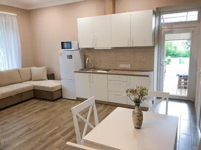 a kitchen and living room with a table and a refrigerator at Marsas in Zarasai