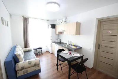 a living room with a blue couch and a table at Ozas Apartment 1 and 2 in Vilnius