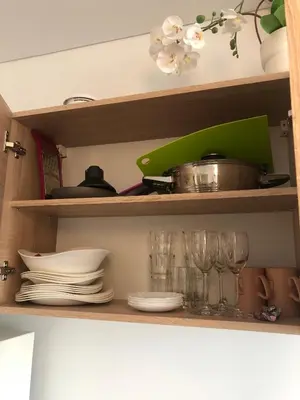 a shelf with plates and glasses and a pot on it at Ozas Apartment 1 and 2 in Vilnius