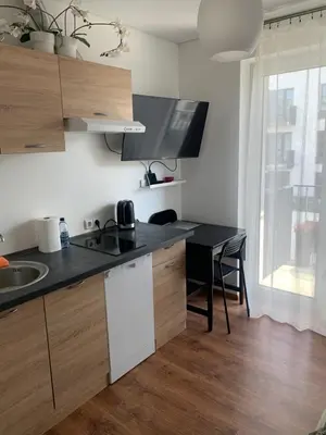 a kitchen with a black counter top and a table at Ozas Apartment 1 and 2 in Vilnius