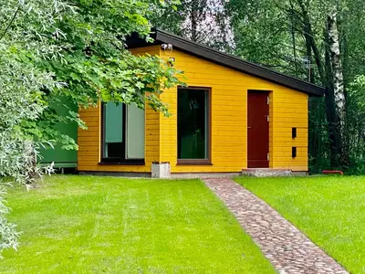 a yellow house with a lawn in front of it at Marijampole Camping in Marijampolė