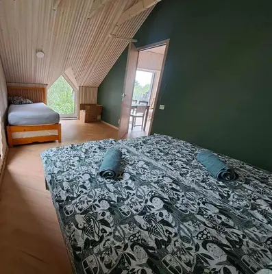 a bedroom with a bed with a black and white bedspread at Lakefront house in Senoji Varėna in Varėna