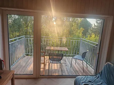 a balcony with a table and chairs on a deck at Lakefront house in Senoji Varėna in Varėna