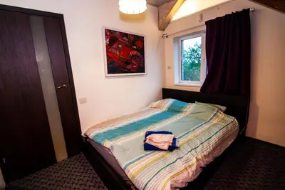 a bedroom with a bed with a bag on it at Lakefront house in Senoji Varėna in Varėna