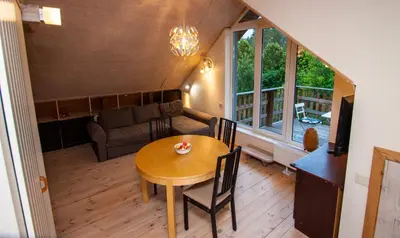 a living room with a table and a couch at Lakefront house in Senoji Varėna in Varėna