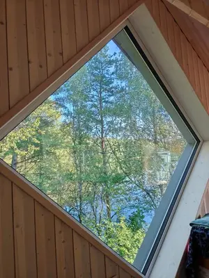 a window in a room with trees in the background at Lakefront house in Senoji Varėna in Varėna