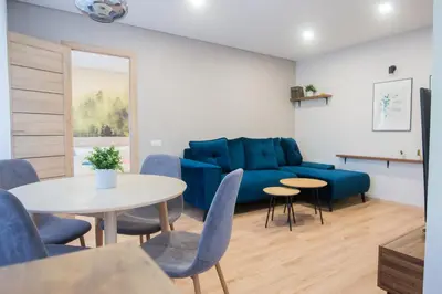 a living room with a blue couch and a table at Central and Relaxing apartment in Druskininkai