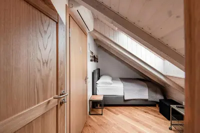 a small bedroom with a bed under the stairs at Small attic rooms in Kaunas old town in Kaunas
