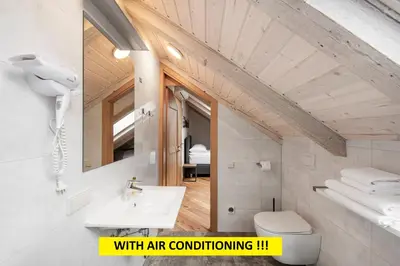 a bathroom with a sink and a toilet and a mirror at Small attic rooms in Kaunas old town in Kaunas