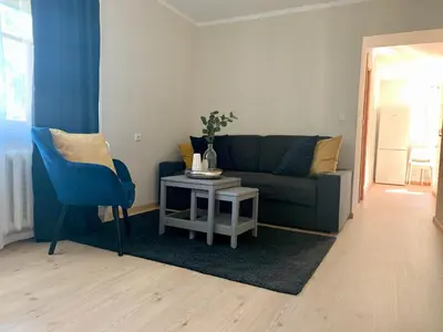 a living room with a couch and a table at Centro Apartamentai in Zarasai