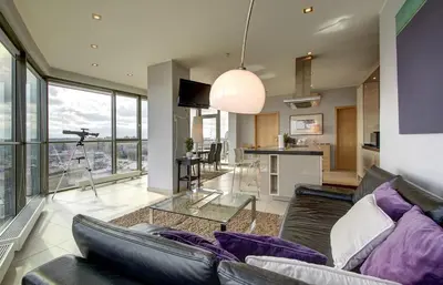 a living room with a couch and a glass table at Helios Luxury apartment in Vilnius skyscraper in Vilnius