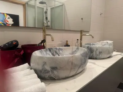 a bathroom with two large marble sinks on a counter at Helios Luxury apartment in Vilnius skyscraper in Vilnius