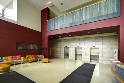 a lobby with couches and tables in a building at Helios Luxury apartment in Vilnius skyscraper in Vilnius