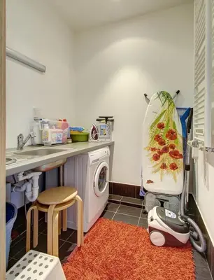 a small kitchen with a washing machine and a counter at Helios Luxury apartment in Vilnius skyscraper in Vilnius