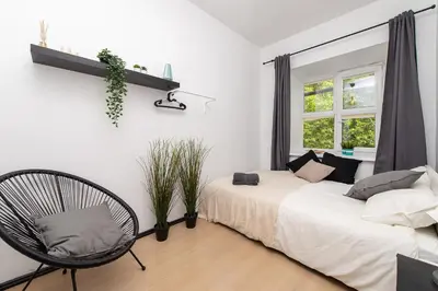 a bedroom with a bed and a chair and a window at The house Vilnius in Vilnius