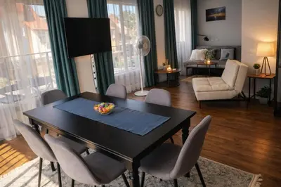 a living room with a dining room table and chairs at Centro apartamentai in Birštonas