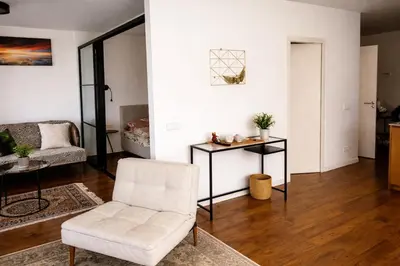 a living room with a white chair and a table at Centro apartamentai in Birštonas