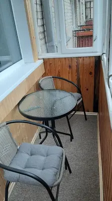 two chairs and a table in a room with a window at Jaukūs apartamentai-studija, centre in Šiauliai