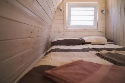 two beds in a small room with a window at Natur Camp Birštonas in Birštonas