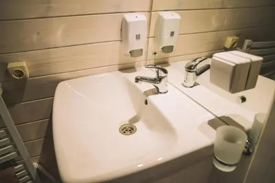 a bathroom with a white sink and a soap dispenser at Natur Camp Birštonas in Birštonas