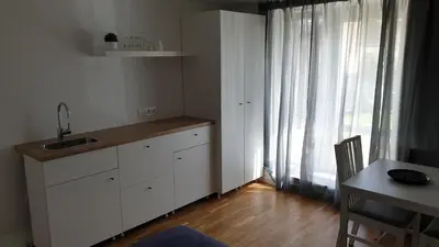 a kitchen with a sink and a table and a window at Muziejaus 10 studija in Anykščiai
