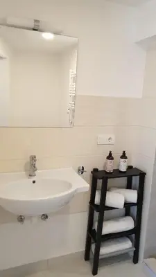 a bathroom with a sink and a mirror and towels at Muziejaus 10 studija in Anykščiai