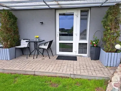 a patio with a table and chairs in front of a door at Muziejaus 10 studija in Anykščiai