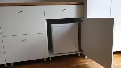 a kitchen with white cabinets and a dishwasher at Muziejaus 10 studija in Anykščiai