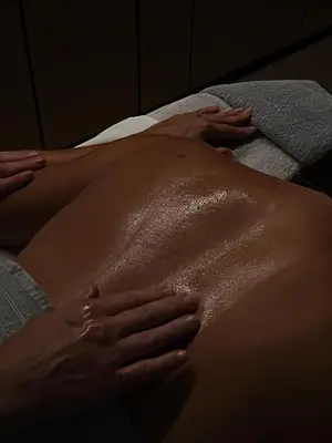 a woman laying on a bed with her stomach at Mana Sleep & Spa in Druskininkai