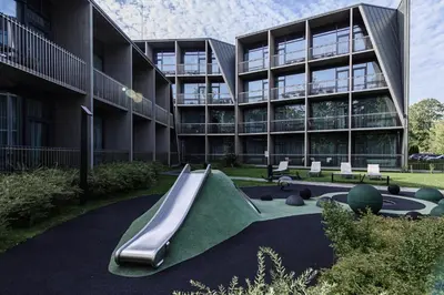 a building with a slide in front of a building at Mana Sleep & Spa in Druskininkai